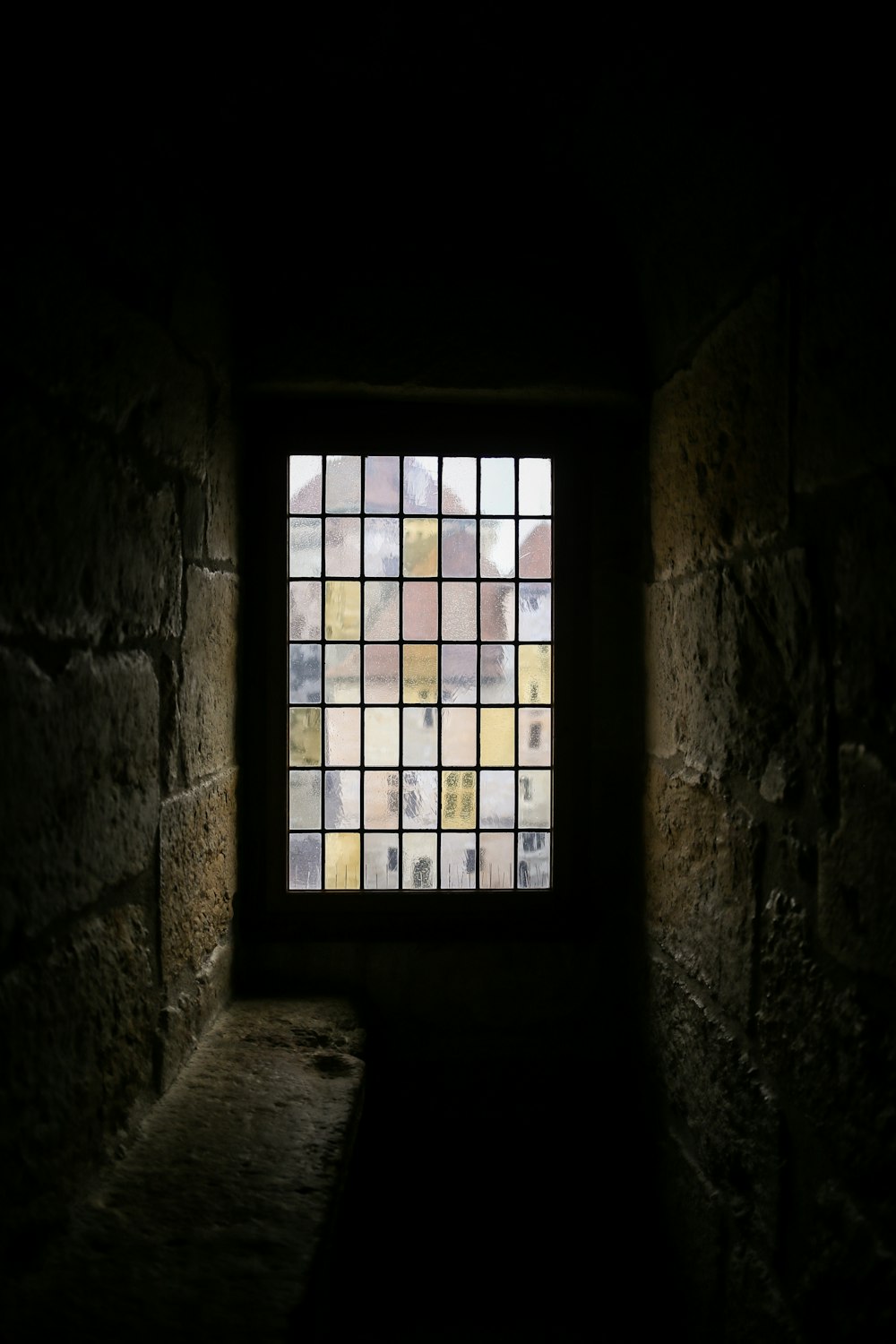 a dark room with a window and a bench