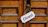 Close-up of a wooden door with a handmade open/closed sign hanging neatly.