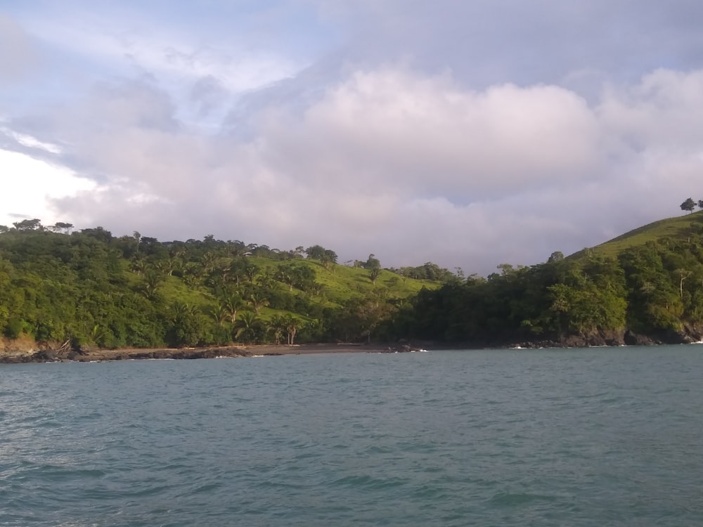 a body of water with a hill in the background