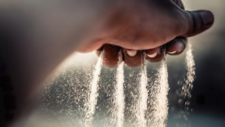 a person's hand sprinkling water from a faucet