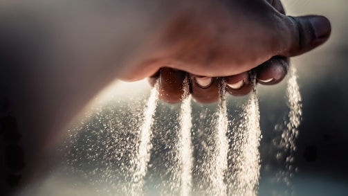 a person's hand sprinkling water from a faucet