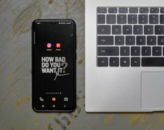 a cell phone sitting next to a laptop computer