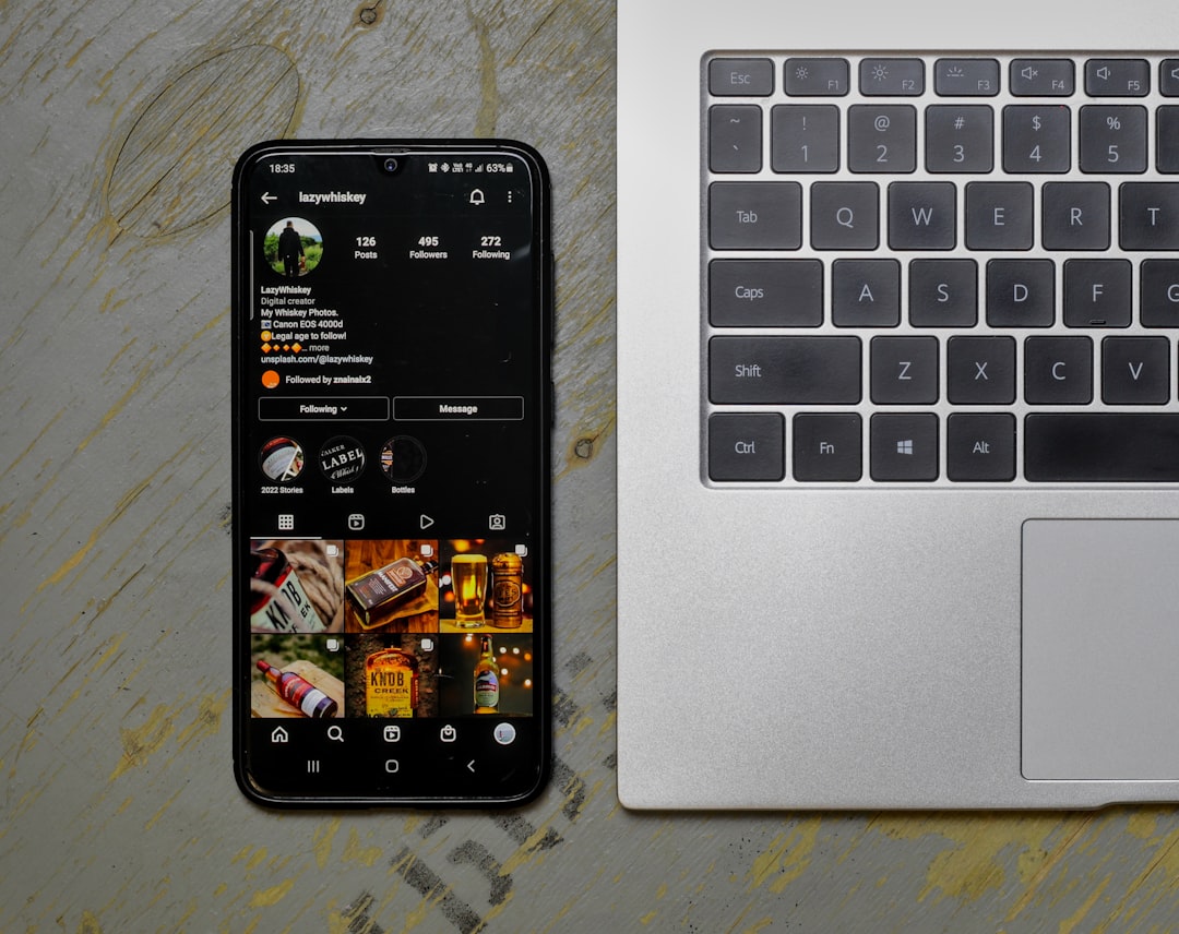 a cell phone sitting next to a laptop computer, Phone with social media icons next to a laptop.