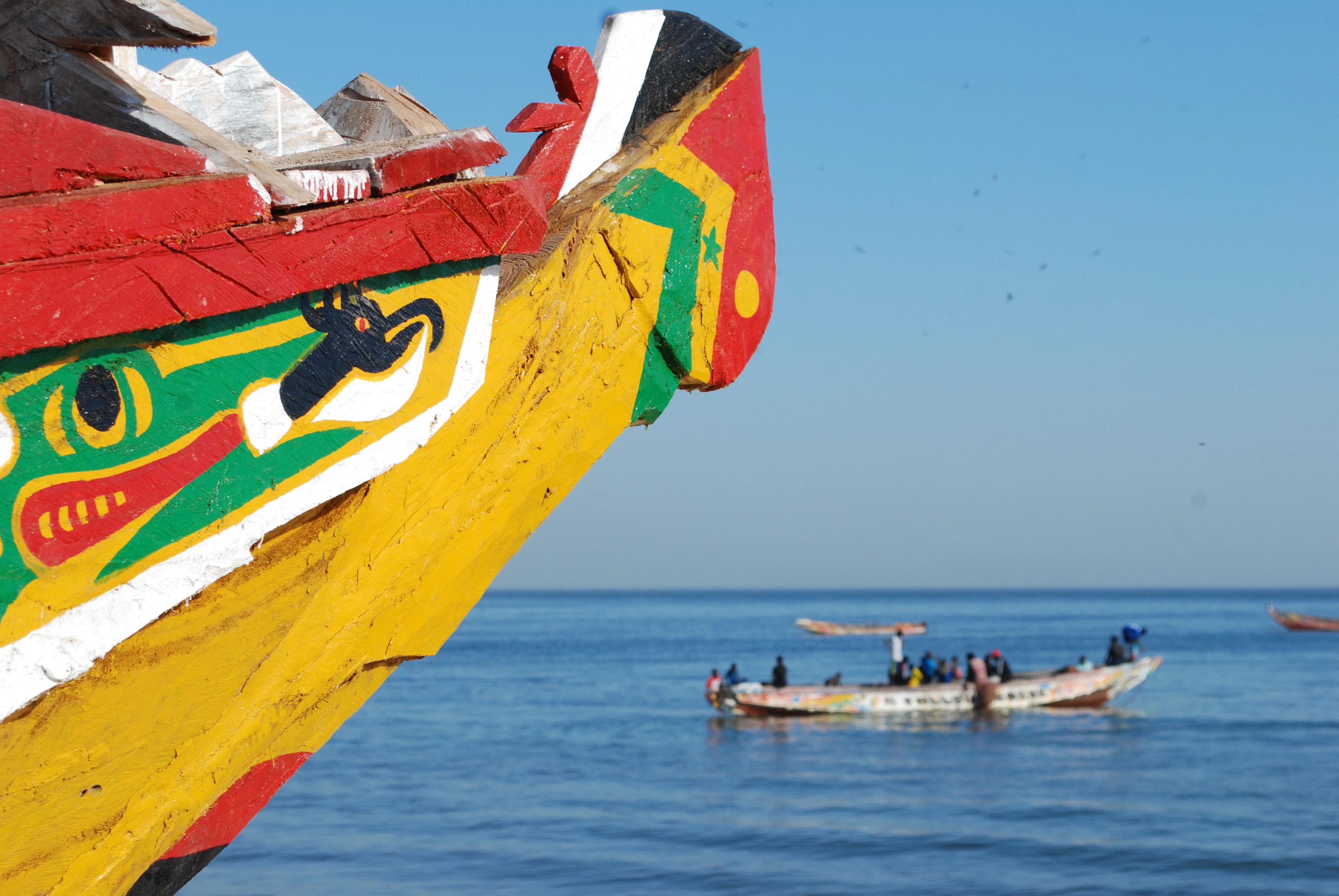 A group of small fishing boats floating close together in calm water