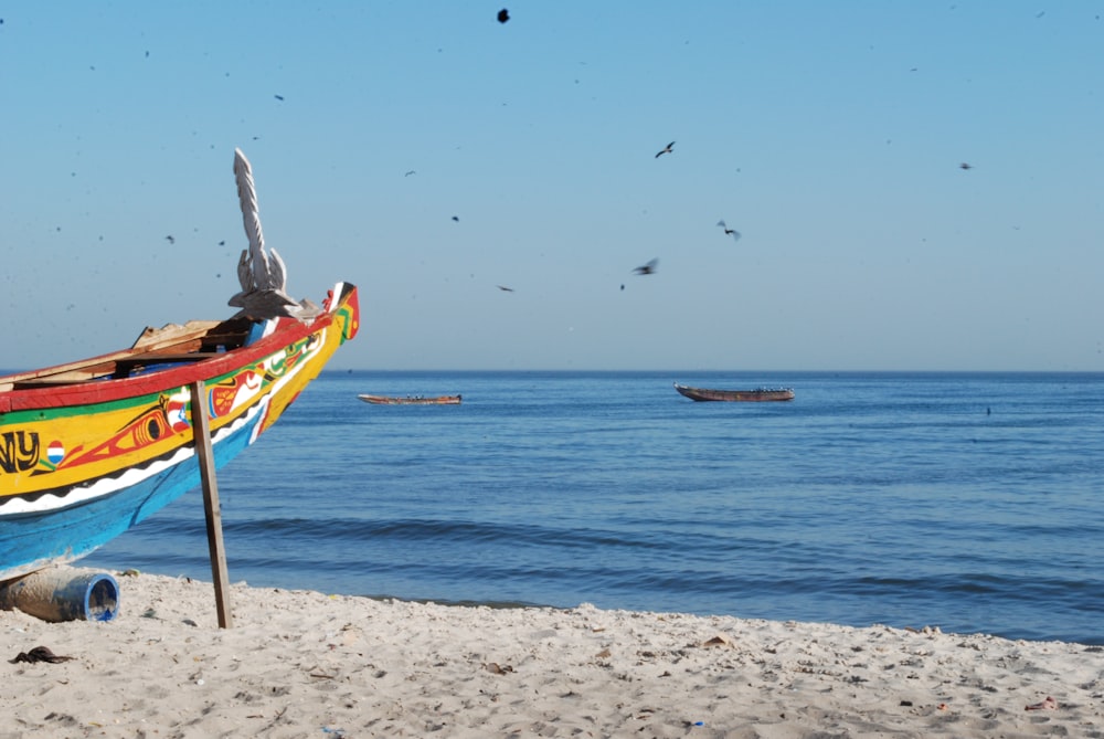 Un colorido barco sentado en la cima de una playa de arena