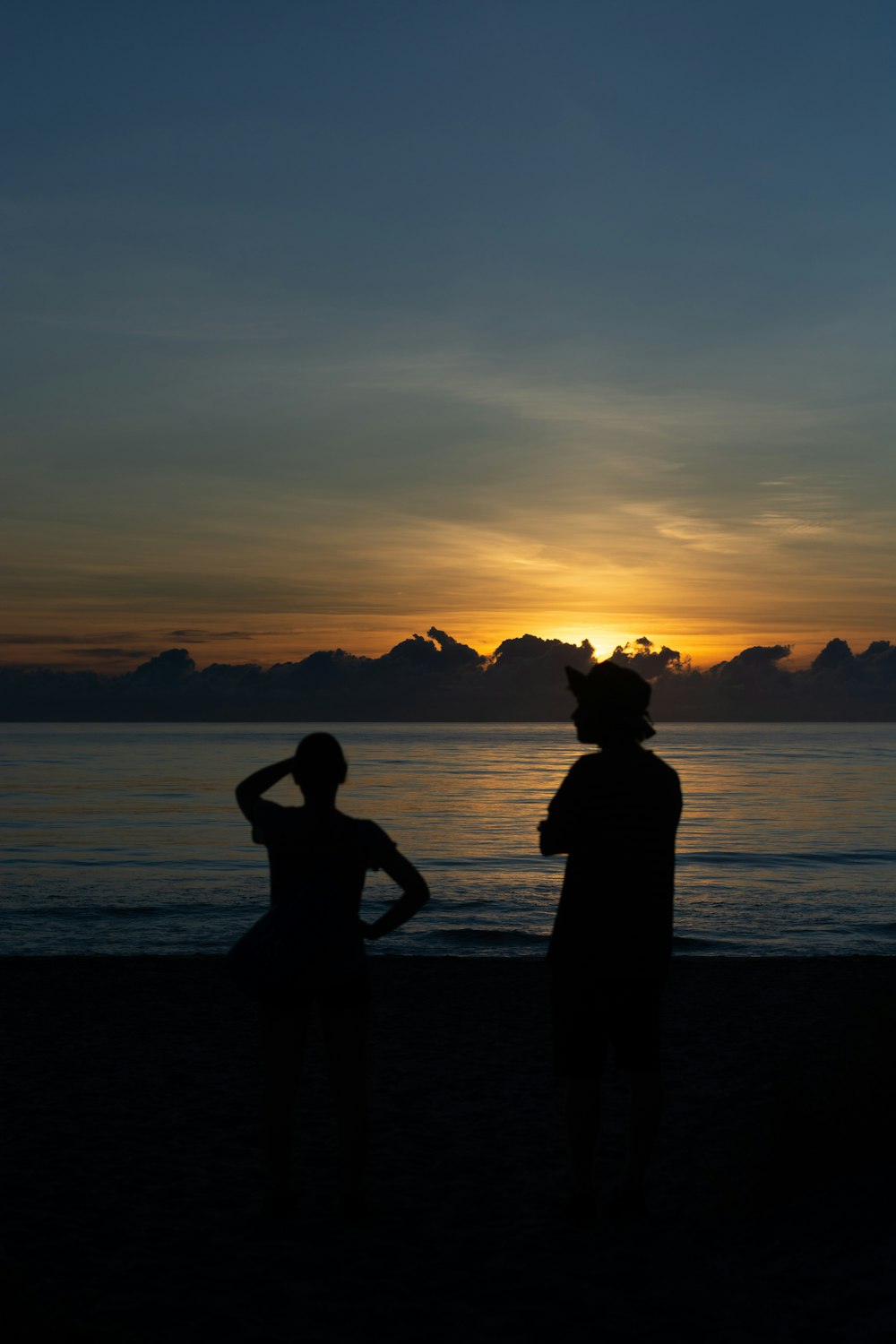 a couple of people standing on top of a beach