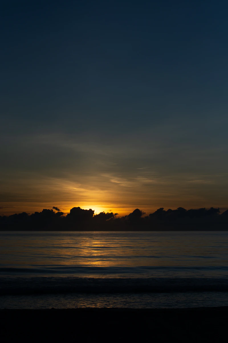 Atlantic Ocean at sunset from the beach at Fort Pierce, Florida — golden hour clouds over the water