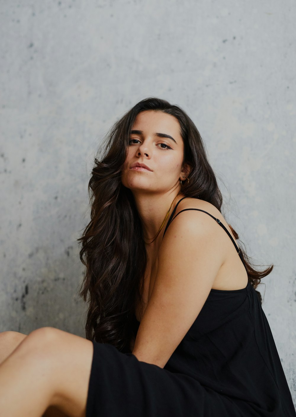 a woman sitting on the ground with her legs crossed