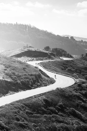 a group of people riding bikes down a winding road
