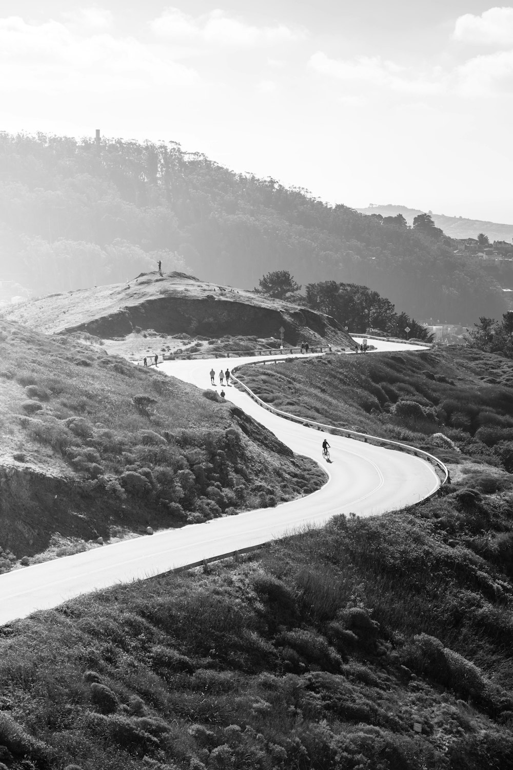 a group of people riding bikes down a winding road