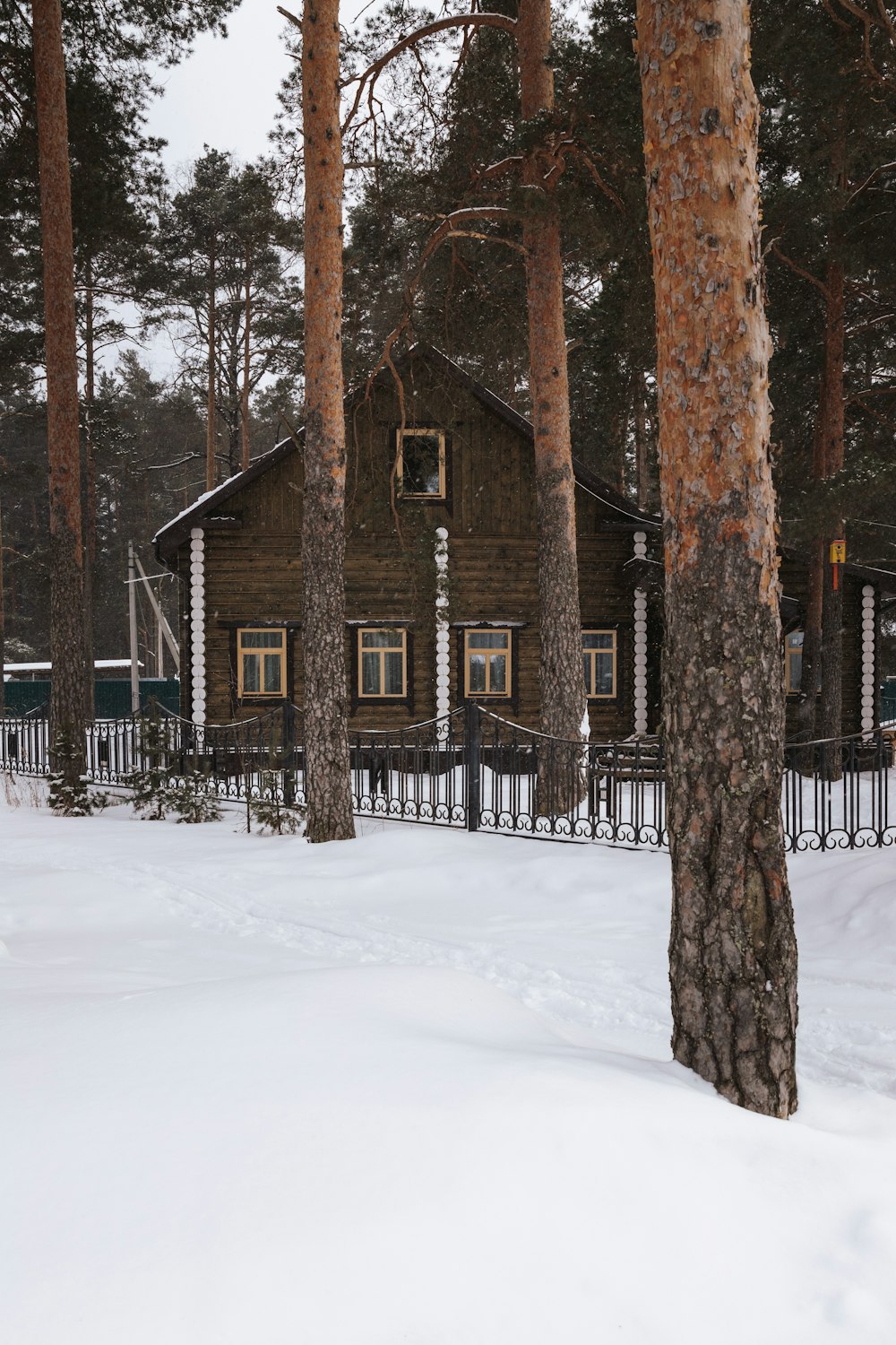 a cabin in the woods with snow on the ground