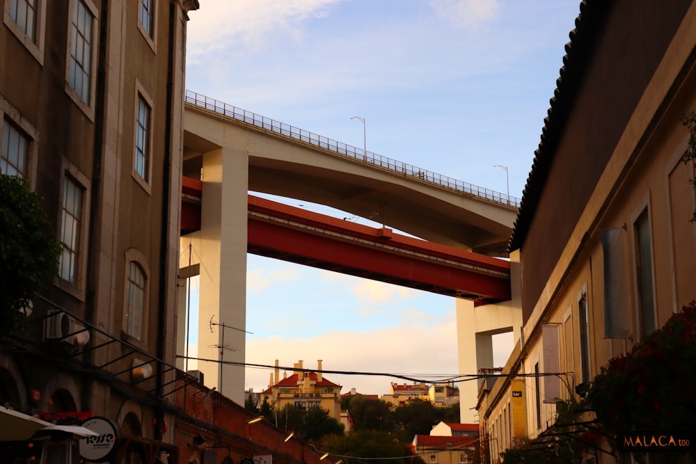 a red and white bridge over a city street