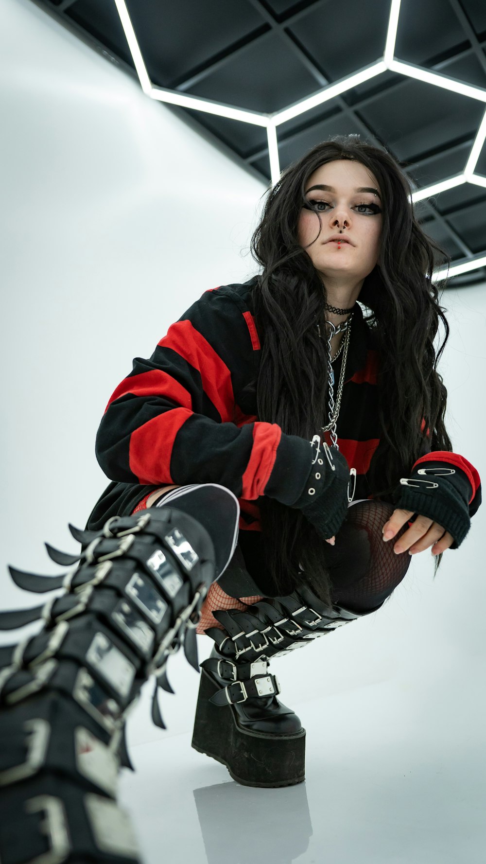 a woman in a black and red jacket and boots