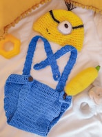 a crocheted bag, banana, and hat on a bed