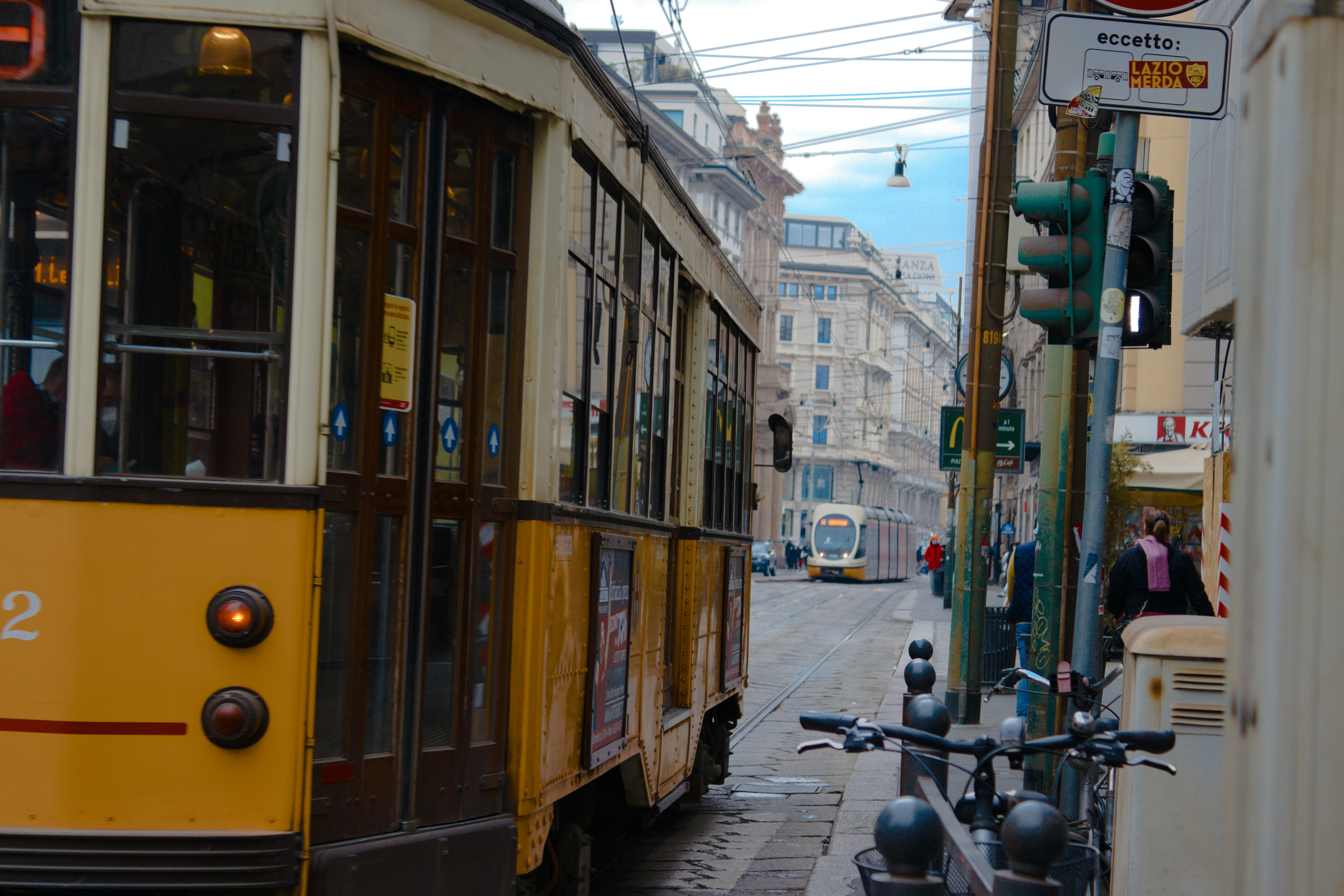 a yellow trolley car on a city street