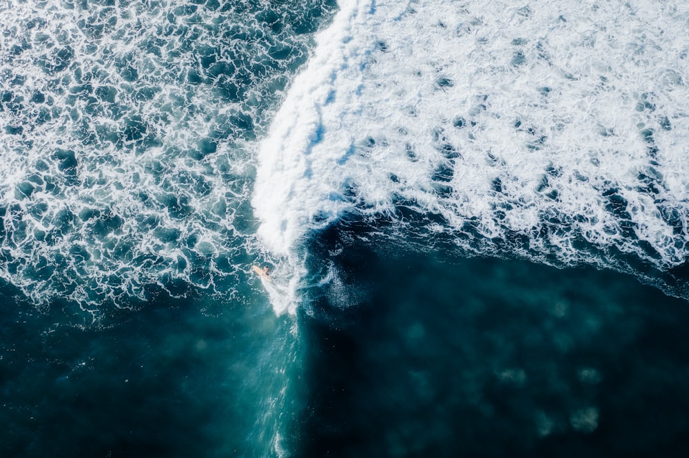 a person riding a surfboard on a wave in the ocean