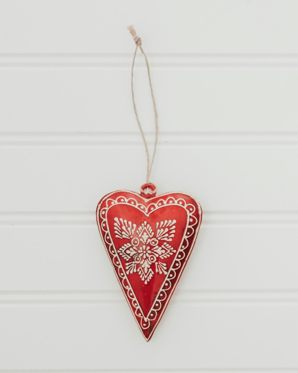 a red heart ornament hanging on a wall