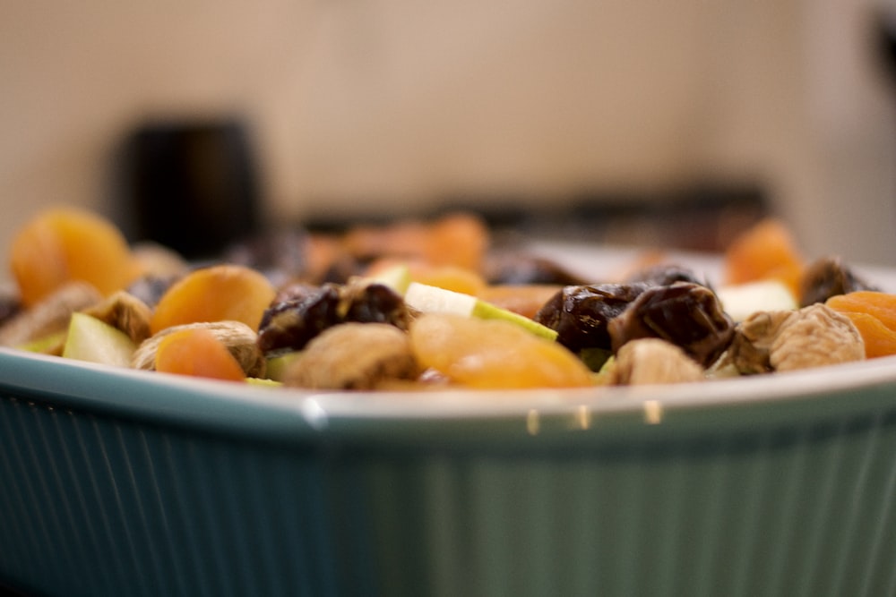 a close up of a bowl of fruit and nuts