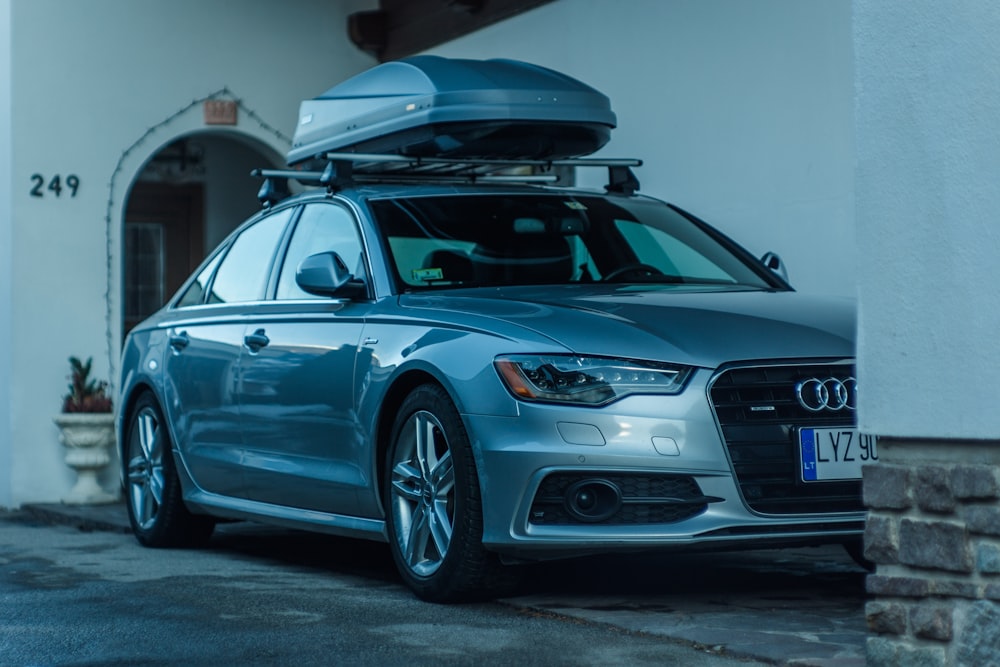 a silver car with a surfboard on top of it