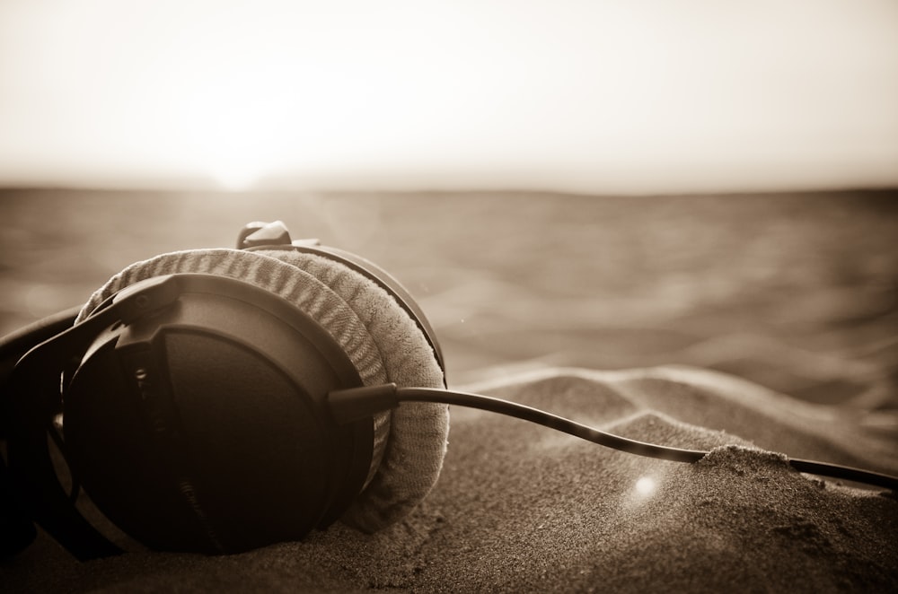 a pair of headphones sitting on top of a sandy beach