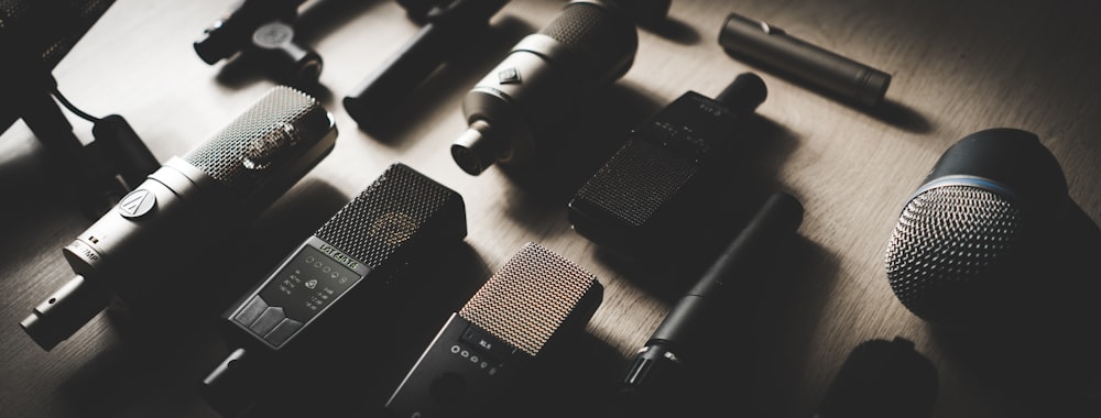 a group of microphones sitting on top of a wooden table