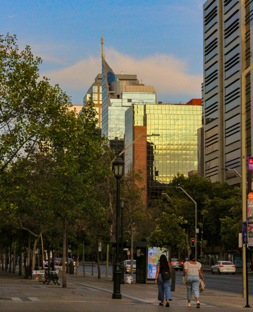 a group of people walking down a street next to tall buildings