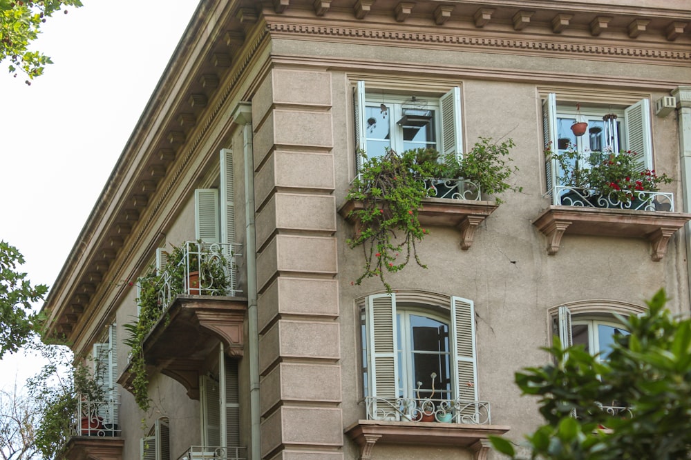 a tall building with many windows and plants on the balconies