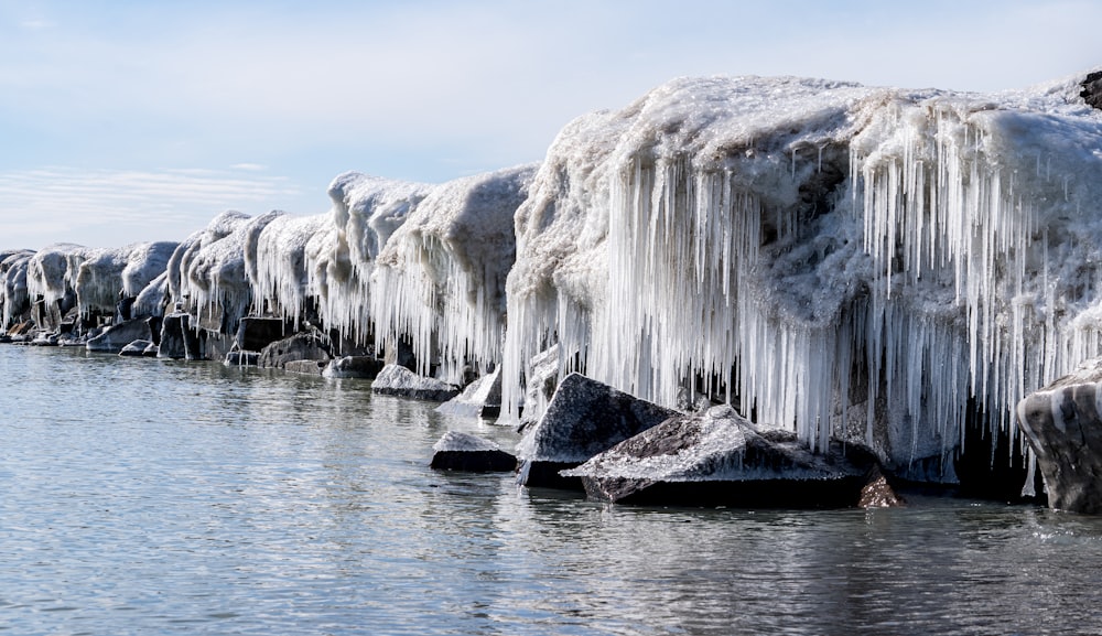 a body of water surrounded by ice covered rocks