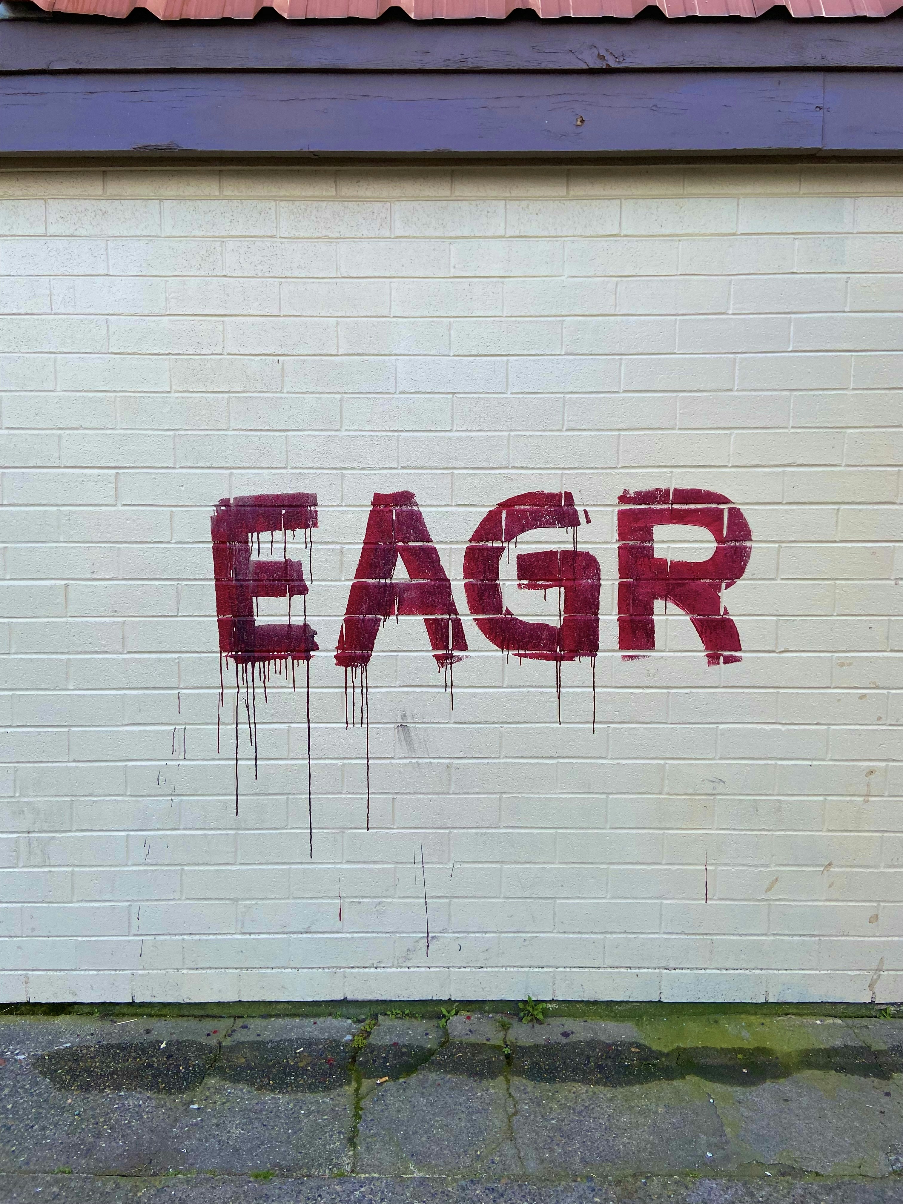 a white brick wall with the word eagr painted on it