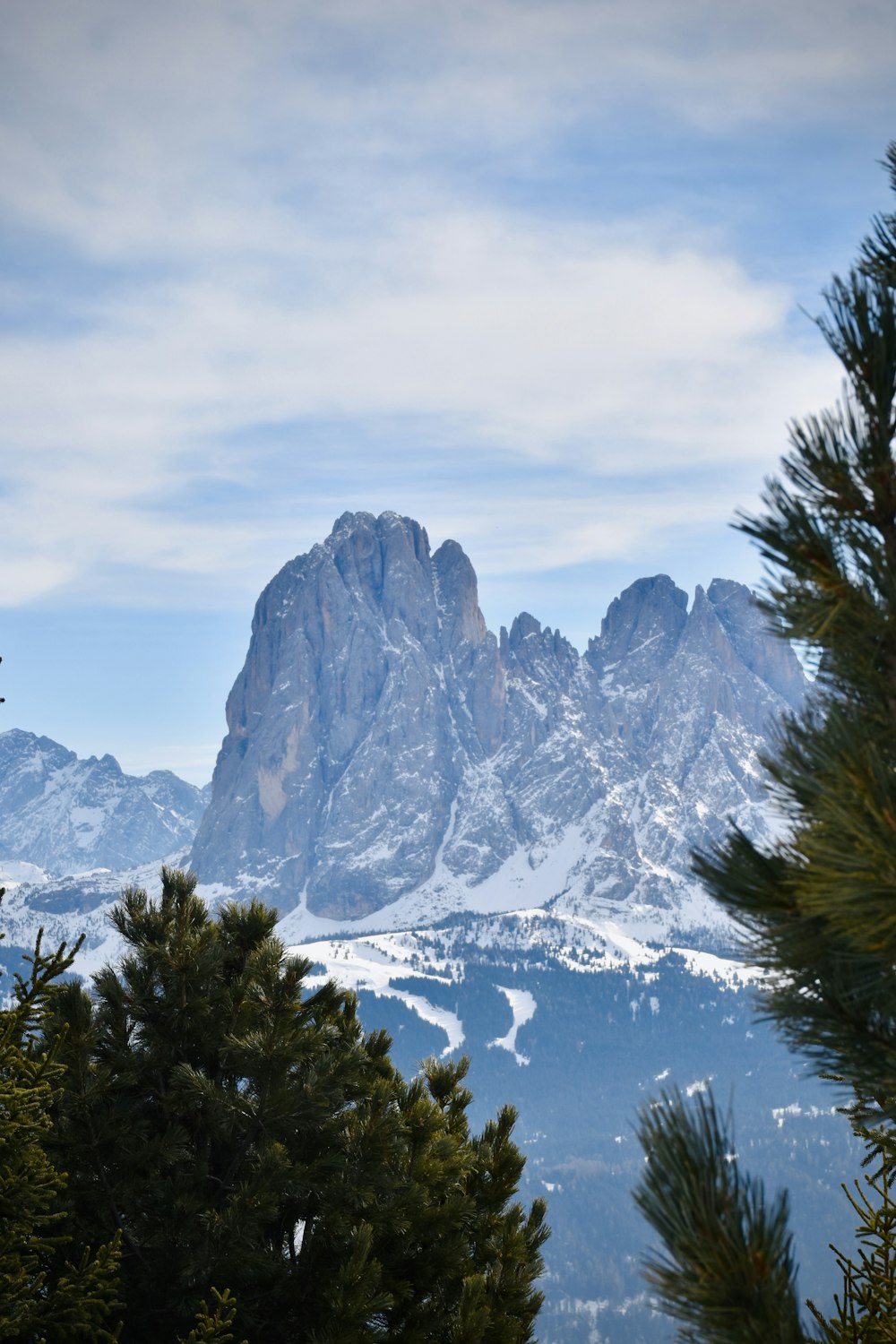 a view of a mountain range with trees in the foreground