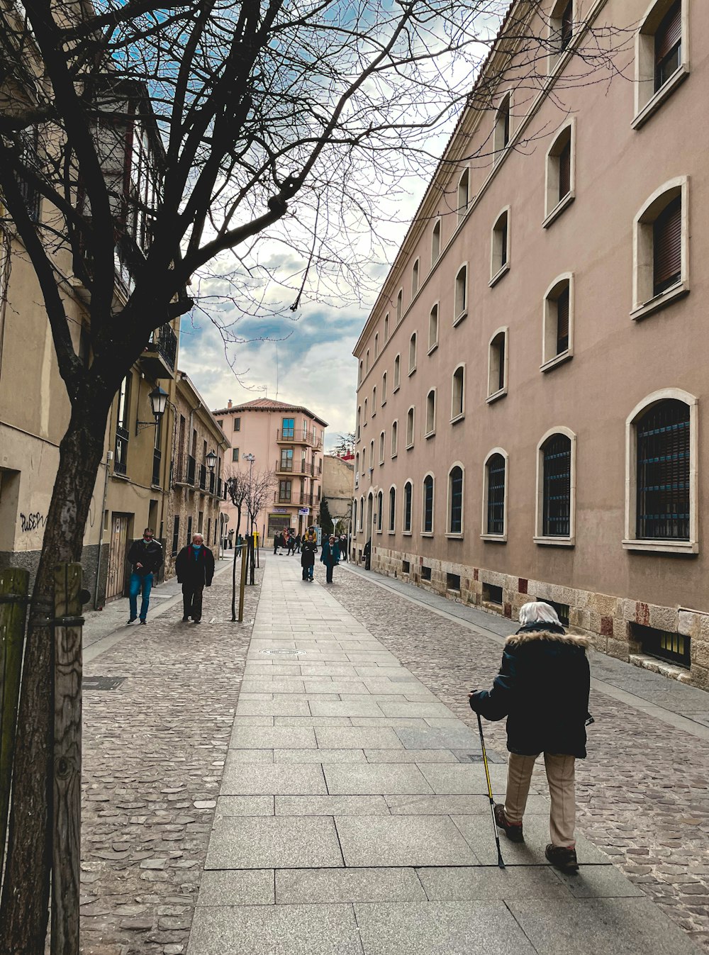 a person walking down a street with a cane
