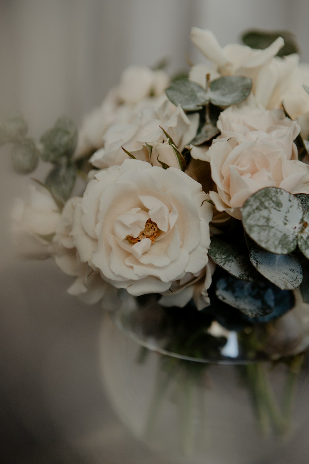 a glass vase filled with white flowers on top of a table