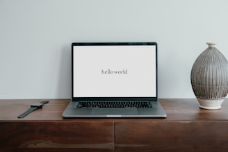 a laptop computer sitting on top of a wooden desk