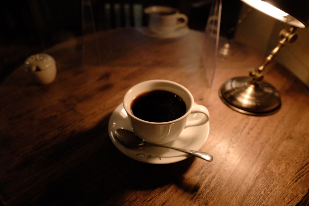 a cup of coffee sitting on top of a wooden table