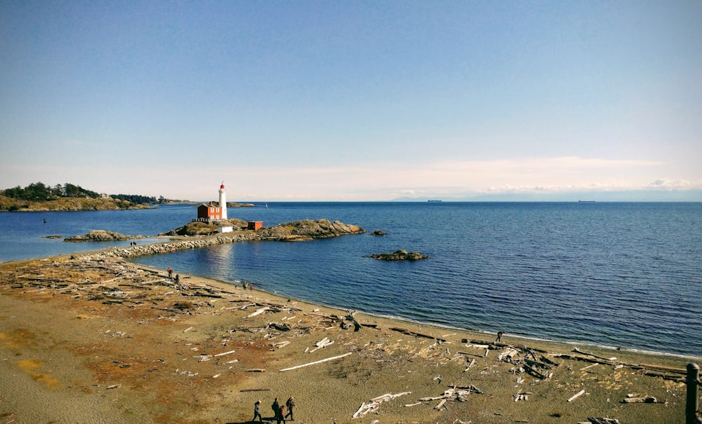 a small light house sitting on top of a rocky shore