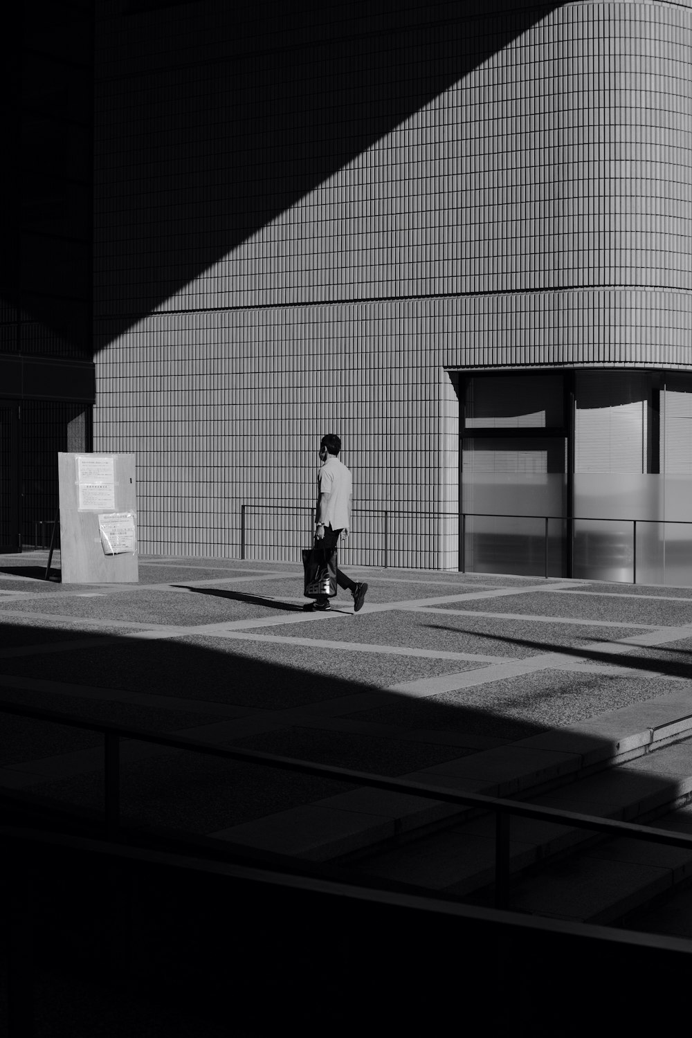 a black and white photo of a person with a suitcase