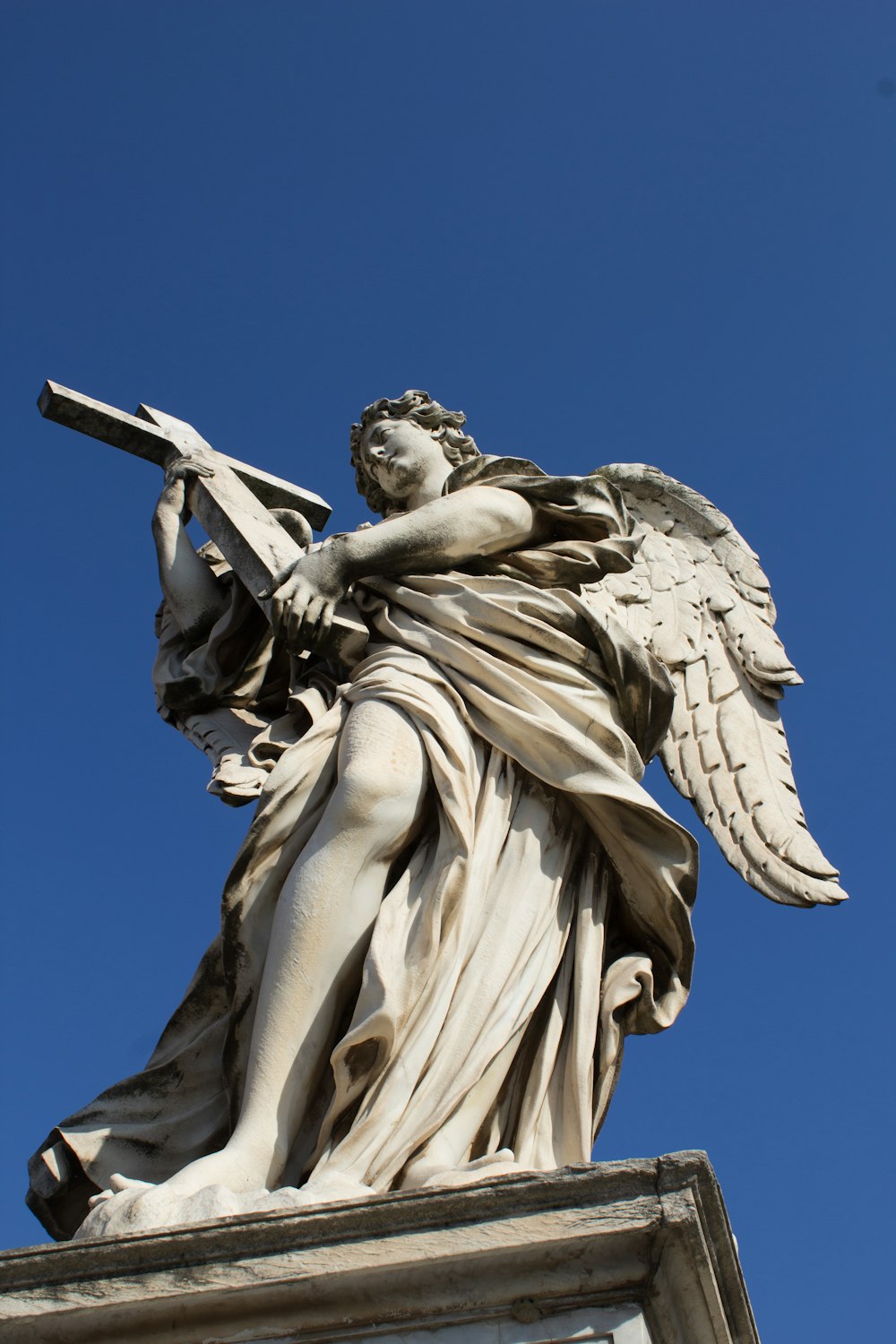 a statue of an angel holding a cross