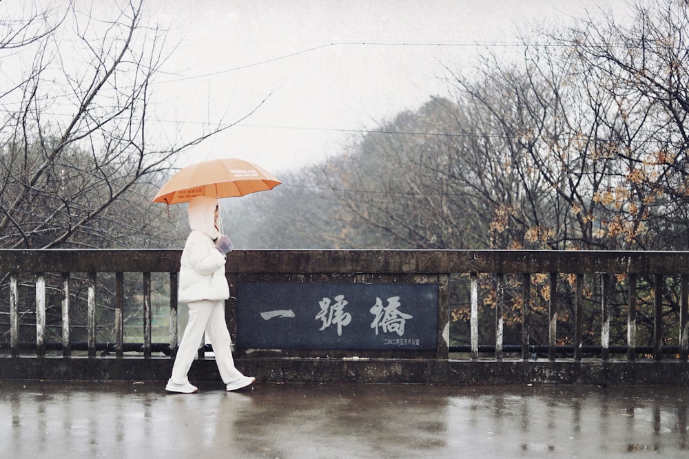 a woman walking in the rain with an umbrella