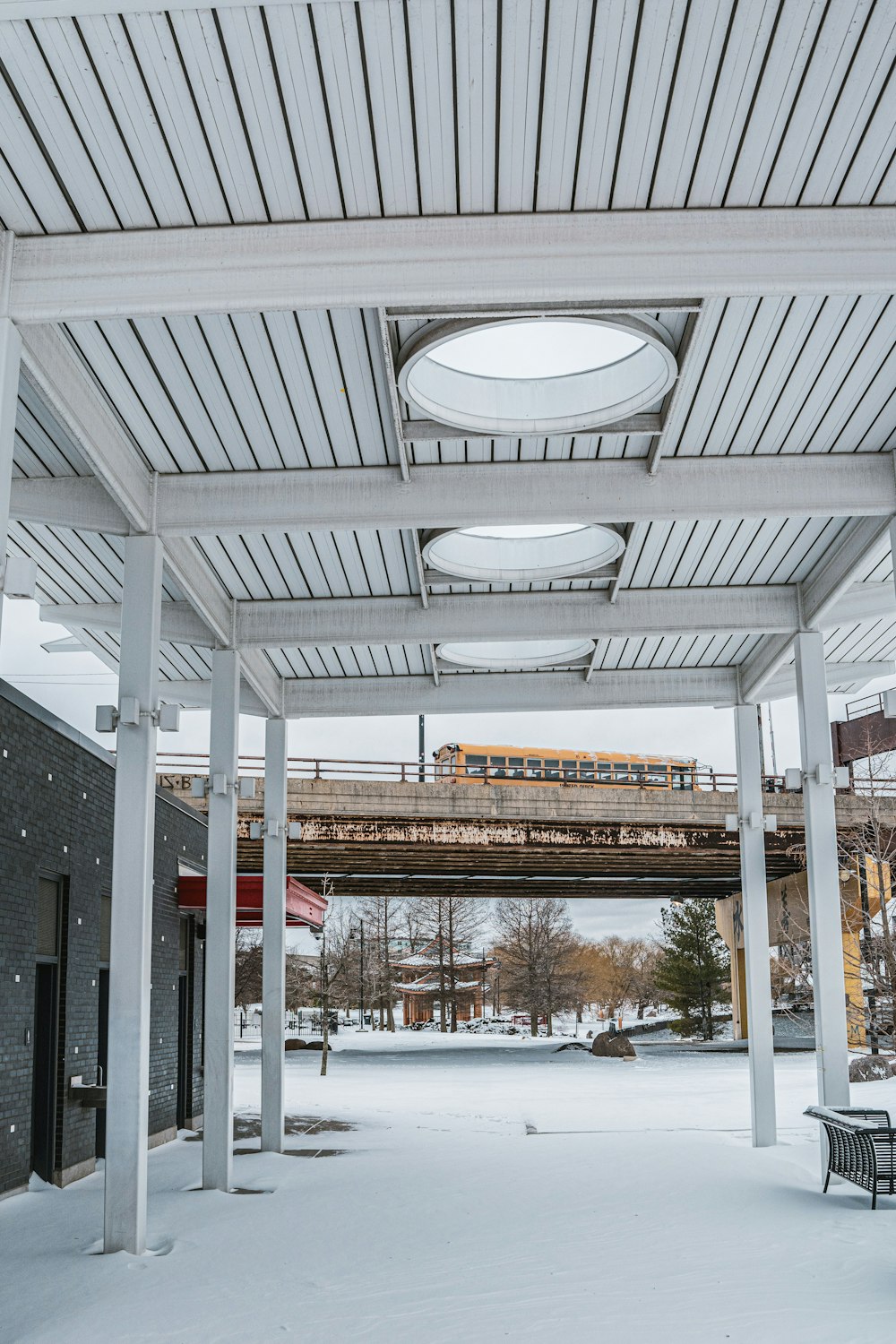 une zone couverte avec des bancs et un train sur une voie