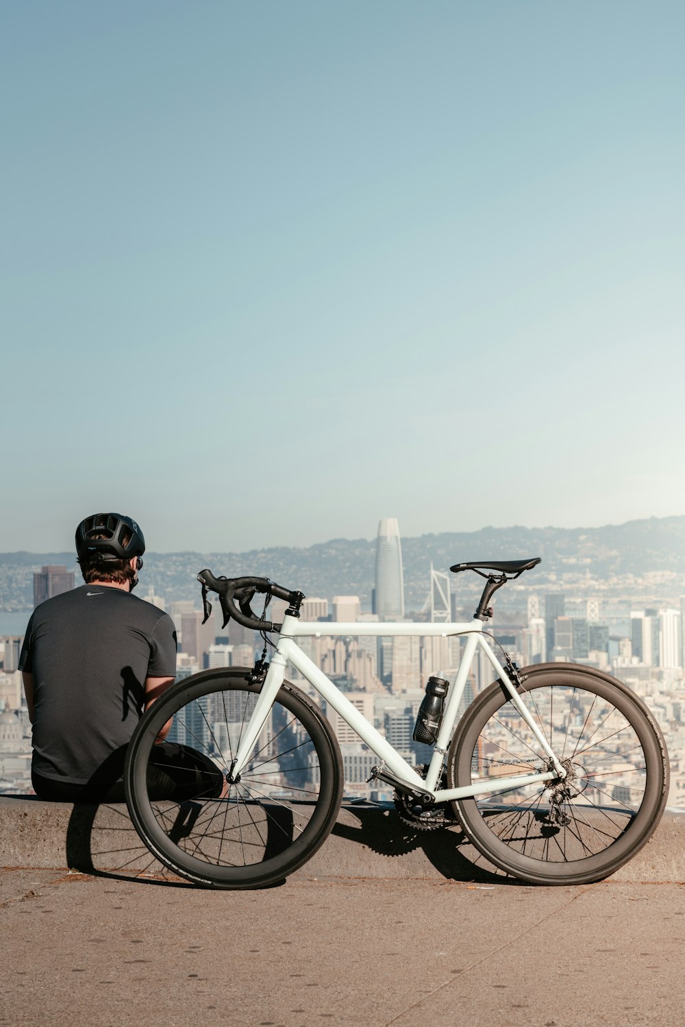 a man sitting on a ledge next to a bike