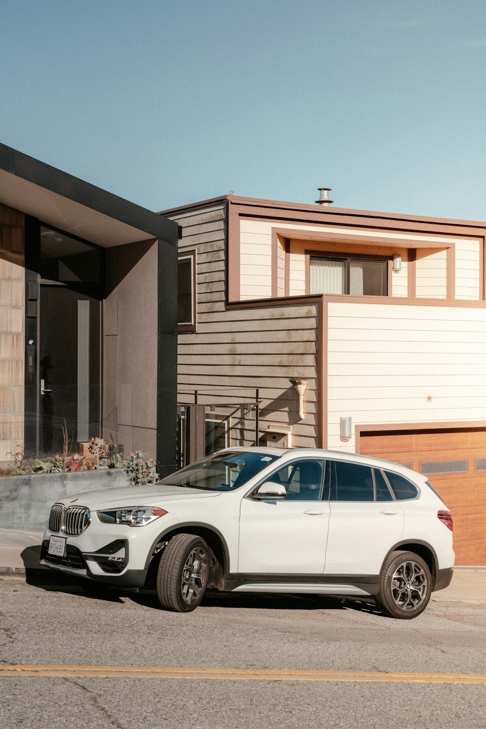 a white car parked in front of a house