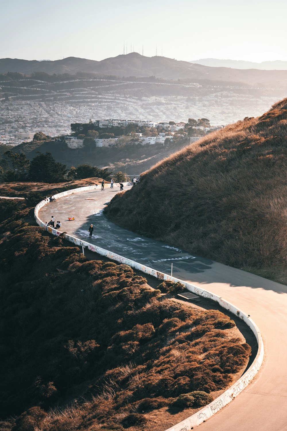 a winding road with a hill in the background