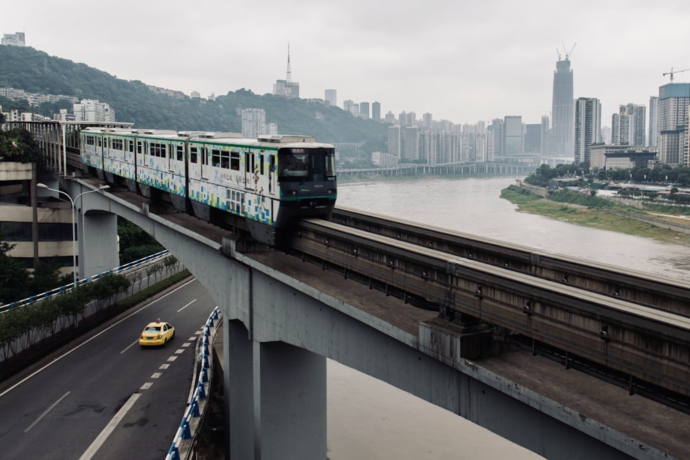 a train on a bridge with a city in the background