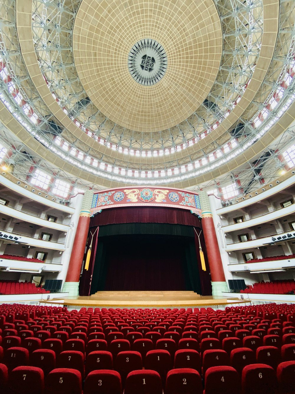 a large auditorium with red seats and a domed ceiling