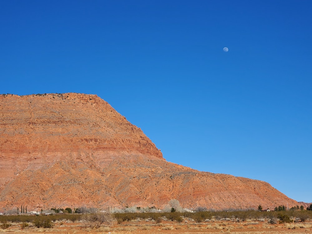 a large mountain with a moon in the sky