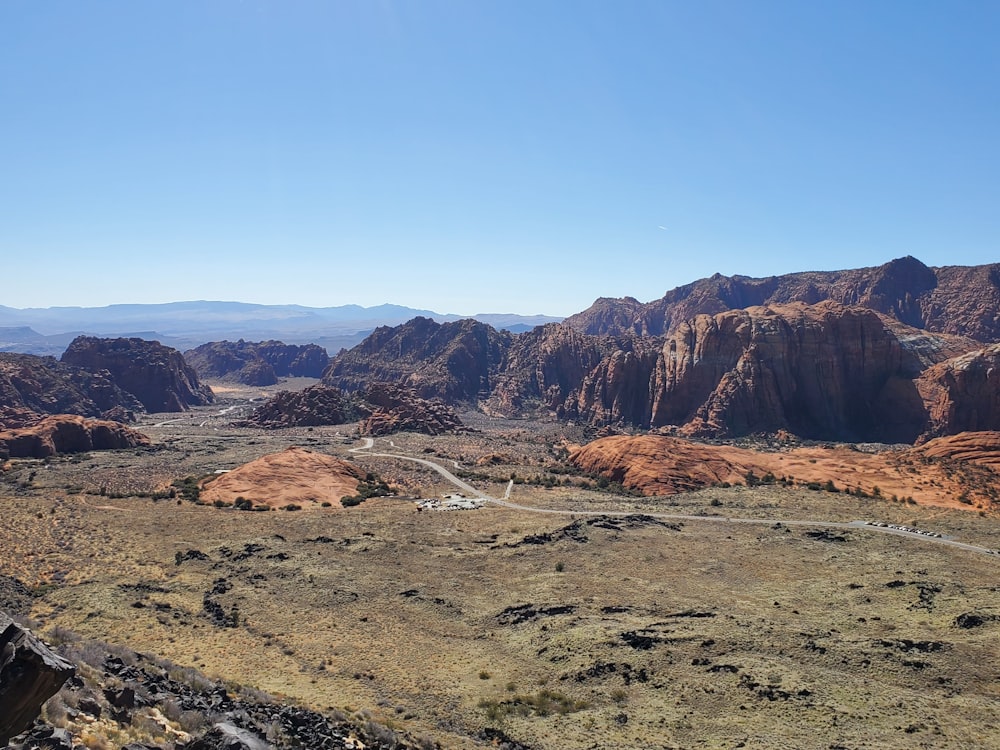 a scenic view of a valley with mountains in the background