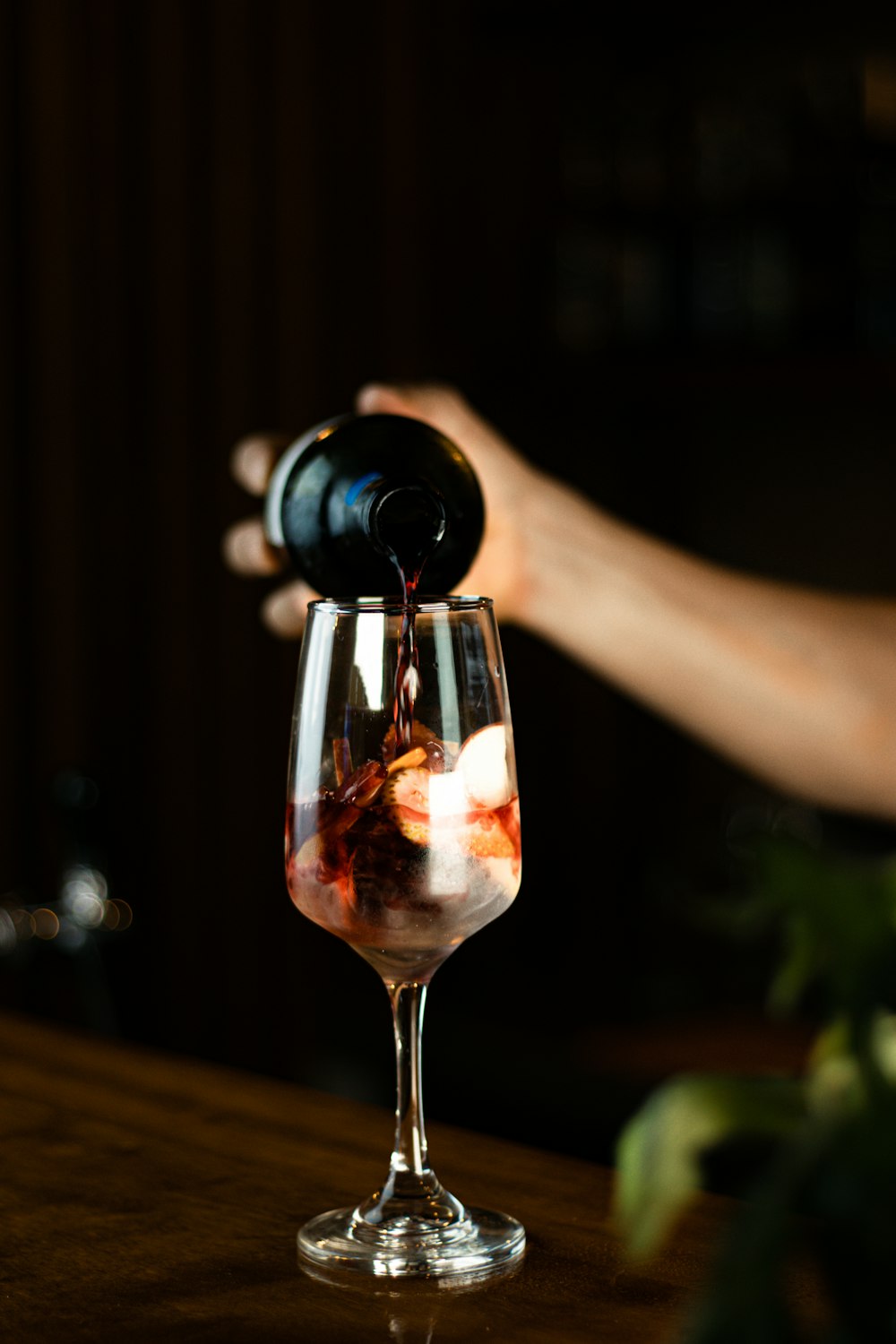 a person pours wine into a wine glass