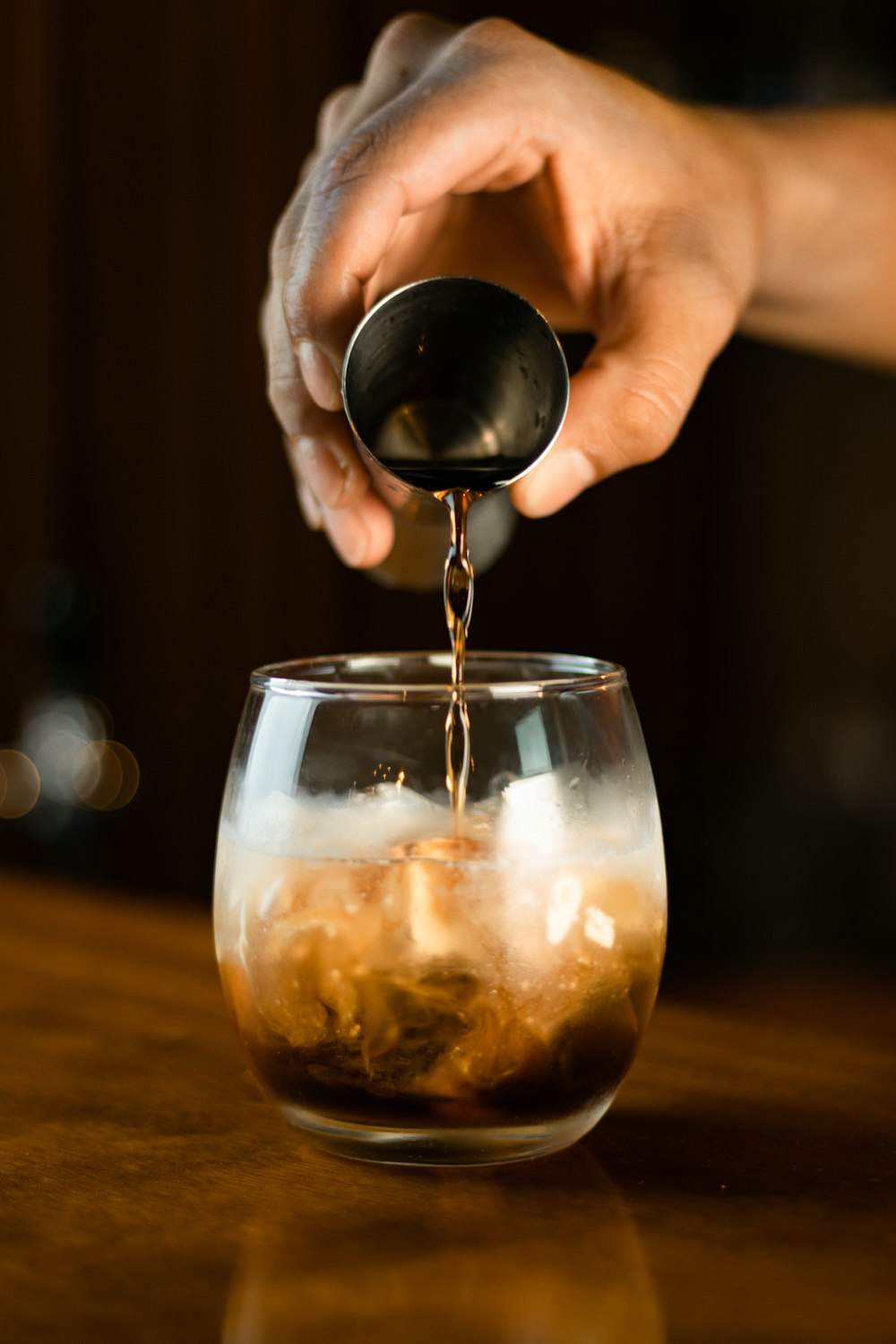 a person pours liquid into a glass