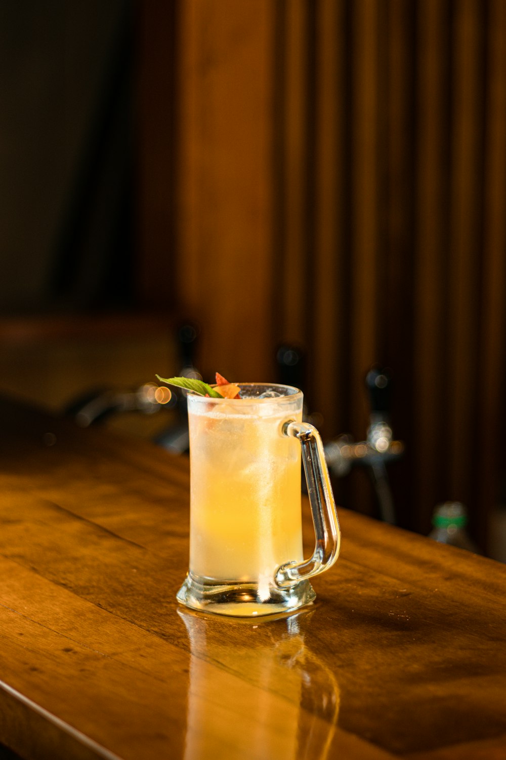 a glass of alcohol sitting on top of a wooden table