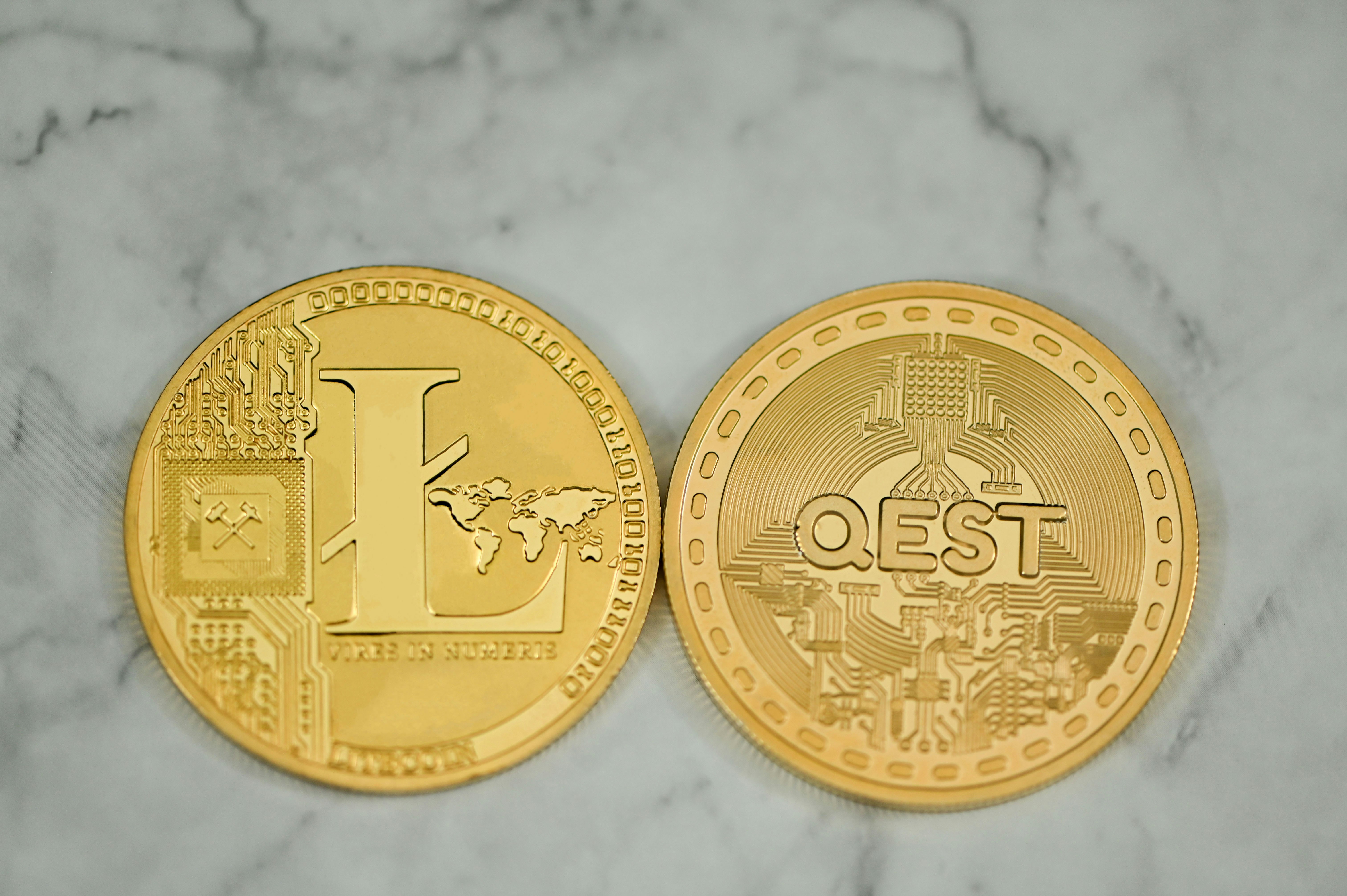 Litecoin and QEST coin together on a marble background
